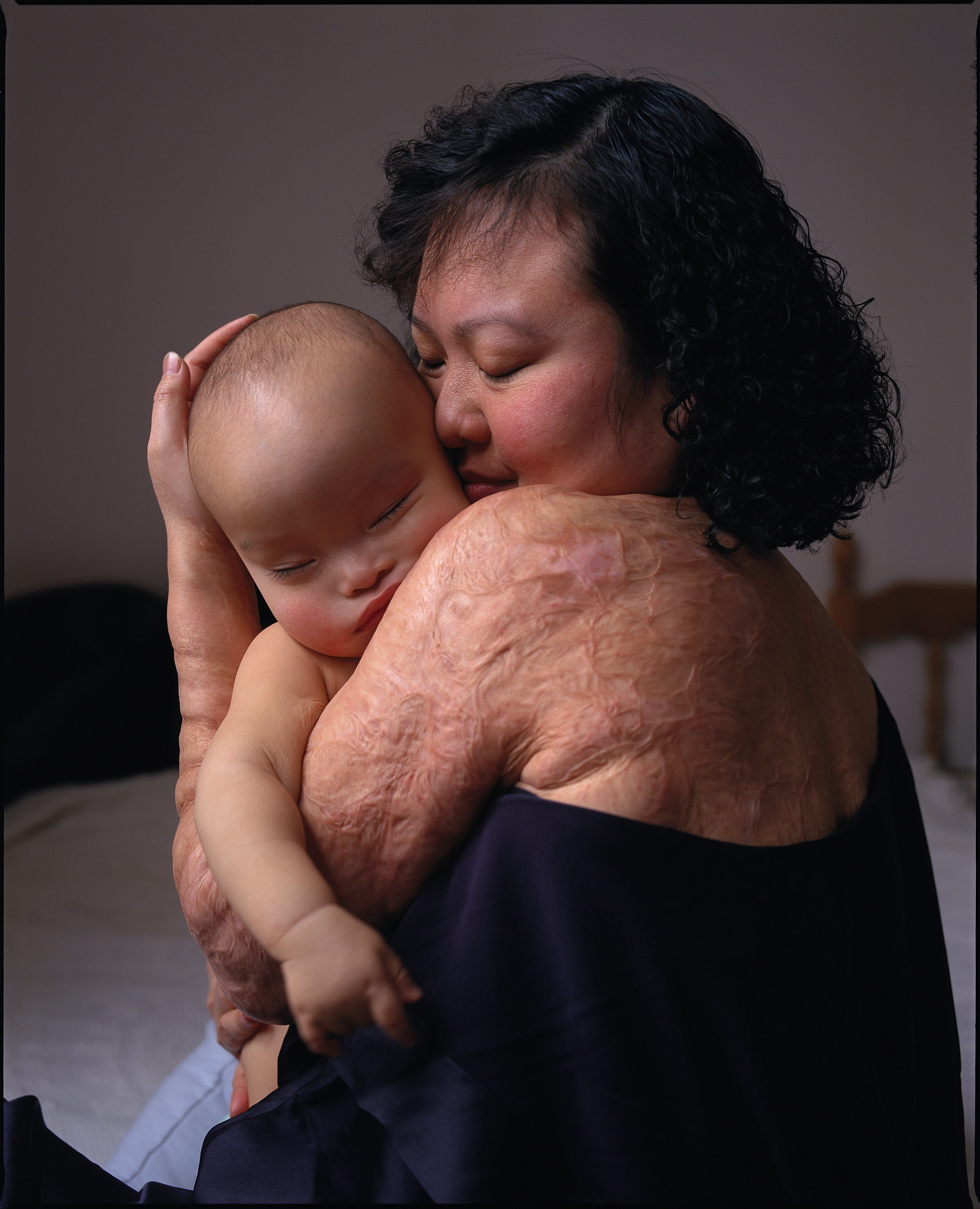 color photograph of Kim Phuc holding her baby